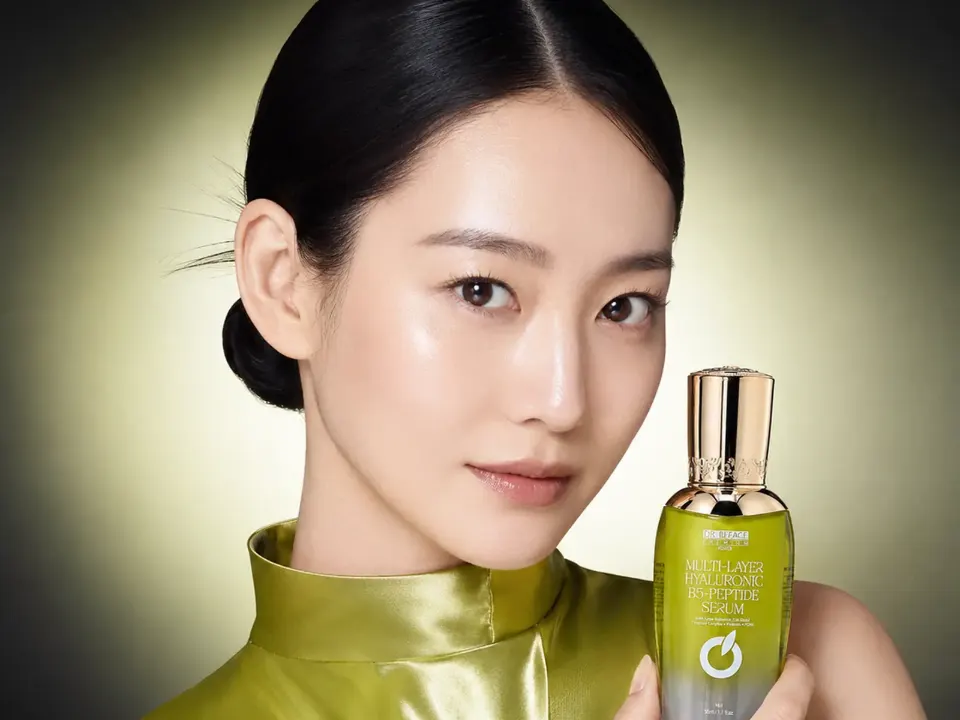 Người mẫu cầm serum Hyaluronic B5 Peptide DR.BEFACE, nền xanh.